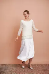 Pollera midi de satén color blanco, de corte evasé.