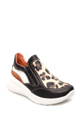 Zapatilla deportiva marrón de cuero liso con detalles en beige y plateado. Presenta cierre lateral y suela gruesa blanca.