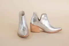Botas plateadas de cuero con puntera en punta y taco de madera.