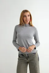 Polera de tejido de punto fino color bordó, con cuello alto y mangas largas.