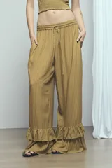 Pantalón marrón con rayas sutiles, de corte ancho y relajado, cintura ajustable con cordón y doble volado fruncido en el ruedo.