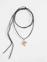 Gargantilla de cordón negro con dije de estrella dorada.