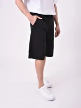 Bermuda de jean negra, corte recto y largo hasta la rodilla.