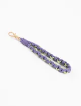Llavero de muñeca tejido a mano con cuerda de algodón color lila y verde, con gancho metálico dorado.