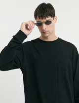 Remera de manga larga color negro, con cuello redondo y puños en punto canalé.