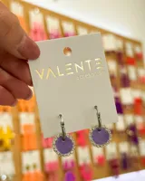 Aros colgantes con aro de acero plateado y dije circular color lila con borde de strass.