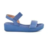 Sandalias azules de cuero con plataforma baja y tiras anchas.