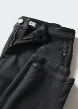 Pantalón tipo jeans skinny con efecto encerado, diseño de cinco bolsillos, cierre de cremallera y botón, y tiro bajo.