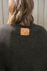 Poncho tejido en hilo de algodón con lurex color negro y dorado, con flecos en el ruedo.