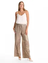 Pantalón wide leg de tiro alto con diseño plisado vertical y acabado metalizado en tono dorado. Presenta una cintura elástica fruncida con lazo de ajuste frontal y bolsillos laterales ocultos.