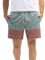 Short de baño de secado rápido, con cintura elástica y cordón ajustable. La parte superior es de color verde agua con un estampado de motivos circulares en tono azul oscuro. La parte inferior es de color terracota con un patrón de microperforaciones.