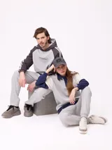 Canguro con capucha de estilo deportivo, con cuerpo en color celeste y mangas raglán en color negro. Presenta el logo de la marca estampado en el pecho, bolsillo tipo canguro frontal y franjas blancas laterales en las mangas.