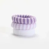 Pack de tres coleteros para el pelo de textura suave y esponjosa, en tonos lila y blanco. Incluye una goma lisa de color blanco, una goma a rayas finas blancas y lilas, y una goma a rayas lilas y blancas.
