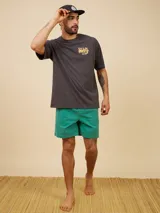 Short de baño tipo volley color amarillo claro, con cintura elástica y cordón ajustable. Presenta un diseño liso con un pequeño logo bordado en la parte inferior de la pierna izquierda.