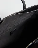 Cartera tipo tote de color negro, con diseño texturizado en el cuerpo y detalles en cuero sintético liso. Cuenta con doble asa superior, correa ajustable y removible, y herrajes plateados.