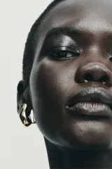 Set de cinco pendientes metálicos dorados con acabado brillante. Incluye cuatro pendientes de diseño irregular con cierre de clip y un pendiente tipo earcuff de aro abierto.