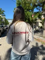 Remera de corte oversize color beige, con estampado gráfico en la espalda en color bordó que incluye el logo y texto descriptivo.