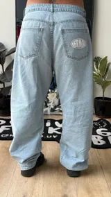 Pantalón de jean estilo baggy, color celeste claro, de tiro alto y corte amplio con detalles bordados en los bolsillos.