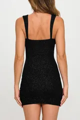 Vestido corto ajustado al cuerpo con acabado glitter brillante, escote redondo y breteles anchos. Presenta un tajo lateral en el ruedo.