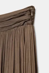 Pantalón bombacho de tiro bajo color marrón, confeccionado en tejido plisado con acabado satinado. Presenta perneras amplias y abullonadas con puños ajustados en los tobillos y cierre lateral con cremallera oculta.