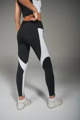 Calza deportiva larga negra con recortes laterales blancos.