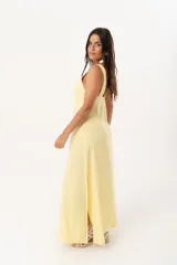 Vestido largo amarillo con escote en V y espalda con tirantes anchos. Confeccionado en lino imperial, con tajos a ambos costados y un diseño que entalla y realza la silueta.