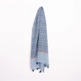 Pashmina rectangular con estampado geométrico en tonos de azul y blanco, con borde inferior decorado con corazones y terminación con flecos.