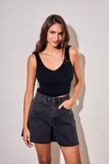Bermuda de jean estilo wide leg, color negro lavado, con tiro medio, bolsillos laterales y ruedo desflecado.