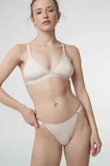 Conjunto de ropa interior con corpiño triangular sin aro y bombacha tipo colaless, ambos con estampado de cebra en tonos beige y blanco, y detalles de puntilla en los bordes.