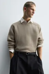 Jersey de punto con diseño boxy fit, cuello redondo y manga larga. Presenta una textura acanalada y acabados en rib en puños y ruedo.