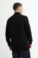 Campera de tejido de punto en color azul marino, con cierre frontal completo y cuello alto. Presenta puños y ruedo acanalados.