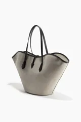 Cartera tipo shopper con diseño de borde superior ondulado y estructura sesgada. Presenta asas finas de cuero negro y un cierre central con detalle metálico dorado. El cuerpo de la cartera posee un patrón geométrico sutil en tonos beige y gris.