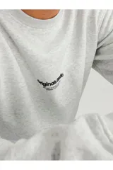 Buzo de cuello redondo y manga larga, confeccionado en tejido de bucle color gris melange. Presenta un corte relajado y un pequeño estampado tipográfico en el centro del pecho.