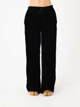 Pantalón negro de terciopelo, corte recto y relajado, con pretina elastizada con cordón ajustable y bolsillos laterales.