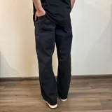 Pantalón de jean corte baggy, color negro, con diseño holgado y tiro medio.