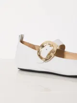 Ballerinas blancas de cuero charol con hebilla dorada y suela negra.