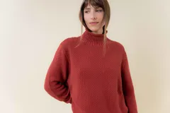 Polera de tejido de punto con textura marcada, cuello alto y diseño oversize con hombros caídos y terminaciones acanaladas.