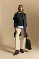 Chaleco tejido color crema con diseño de rombos calados, cuello redondo y sisas.