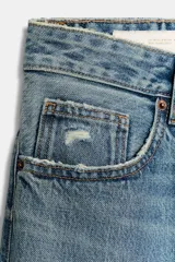 Jeans de corte boyfriend y tiro medio, con diseño de cinco bolsillos, cierre frontal con cremallera y botón metálico. Presenta un acabado lavado con detalles de roturas y desgastes.