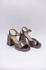 Sandalias de cuero color peltre con plataforma y pulsera al tobillo. Taco cuadrado de 9 cm de altura.