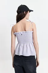 Blusa de algodón a cuadros color celeste y rosado, con escote recto, breteles finos y fruncido en el cuerpo.