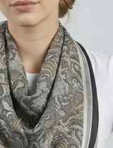 Bandana cuadrada de satén con estampado de arabescos en tonos naranja, blanco y marrón.