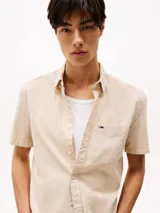 Camisa de corte regular confeccionada en puro algodón mil rayas con una sutil textura. Diseño integral de rayas verticales, cuello con botones, bolsillo de parche en el pecho, detalles distintivos de Tommy Jeans y parche con el logo de Tommy Jeans en el bolsillo.