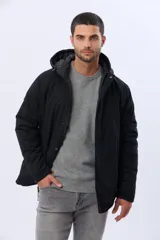 Campera puffer reversible para hombre, de color negro, con diseño capitonado, capucha integrada y bolsillos funcionales con cierre frontal.