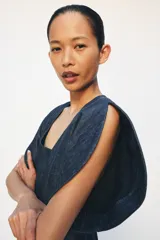 Blusa de Zara confeccionada en mezcla de algodón con acabado denim. Presenta escote redondo, mangas cortas abullonadas con volumen y costuras con pespuntes a contraste. Cierre posterior con cremallera oculta.