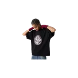 Remera negra de corte oversize con cuello redondo, mangas cortas amplias y gran estampado circular frontal en tonos blancos y marrones con inscripciones de la marca.