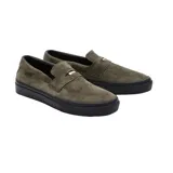Championes Vans modelo Skate en colaboración con Beatrice Domond, de estilo mocasín slip-on. Confeccionados en gamuza color verde oliva, cuentan con suela de goma vulcanizada negra y detalle de etiqueta lateral a cuadros.