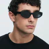 Gafas de sol Mara con montura ovalada negra y lentes polarizadas negras.