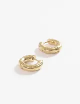 Aros tipo argolla gruesos con superficie texturada, fabricados en acero quirúrgico hipoalergénico de color plateado.