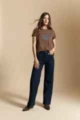 Remera de manga corta color marrón, con la frase "la dolce vita" bordada en azul en el frente y mangas con dobladillo.